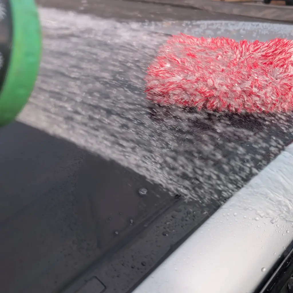 Chemical Guys Heavy Duty Water Spot Remover bottle during glass cleaning