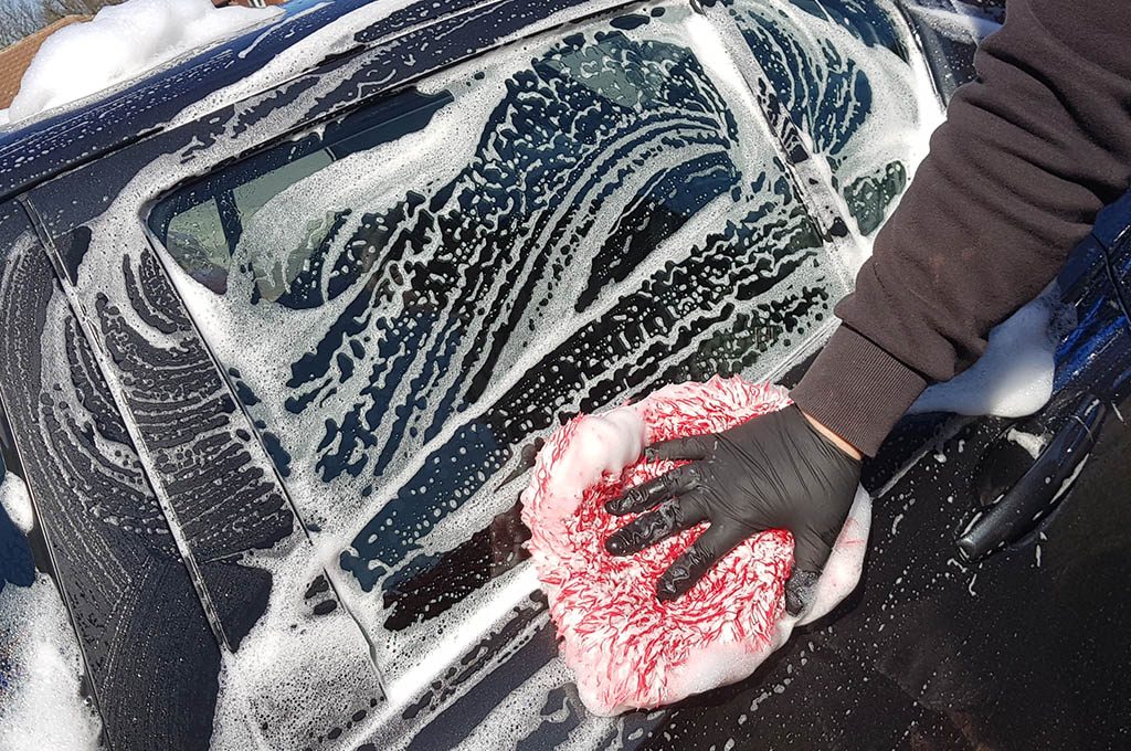 cleaning car with shampoo and washmitt